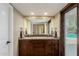 Bathroom showcasing a double vanity with a dark wood cabinet and direct access to the pool at 410 E Beck Ln, Phoenix, AZ 85022