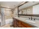 Elegant bathroom featuring a dual sink vanity with granite countertops and a tiled shower-tub combination at 410 E Beck Ln, Phoenix, AZ 85022