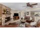Cozy living room with a brick fireplace, comfortable leather seating, and a ceiling fan at 410 E Beck Ln, Phoenix, AZ 85022