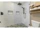Modern shower with subway tile walls, pebble floor, and niche shelves for storage at 410 E Beck Ln, Phoenix, AZ 85022