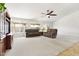 Bright living room with plush carpet, ceiling fan, and large windows overlooking the backyard at 4213 W Calle Lejos --, Glendale, AZ 85310
