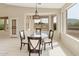 This dining room features a glass table, cushioned chairs, and windows overlooking the yard at 4316 E Strawberry Dr, Gilbert, AZ 85298