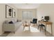 This living room features a modern sofa, accent chair, contemporary art, and a work space at 4316 E Strawberry Dr, Gilbert, AZ 85298