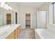 Bright main bathroom with double sink vanity, walk-in closet, soaking tub and glass enclosed shower at 4316 E Strawberry Dr, Gilbert, AZ 85298