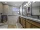 Bathroom showcasing tiled shower, wood vanity, dual sinks, granite counters, and custom fixtures at 43330 W Delia Blvd, Maricopa, AZ 85138
