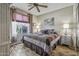 Cozy bedroom with ceiling fan, wood floors, and natural light from the window at 43330 W Delia Blvd, Maricopa, AZ 85138