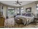 Main bedroom offers wood-look floors, large windows, a ceiling fan, and a comfortable layout at 43330 W Delia Blvd, Maricopa, AZ 85138