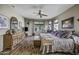 Comfortable main bedroom offers wood-look floors, ceiling fan, and large windows at 43330 W Delia Blvd, Maricopa, AZ 85138