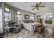 Comfortable main bedroom features wood-look floors, ceiling fan, and a leather reading chair at 43330 W Delia Blvd, Maricopa, AZ 85138