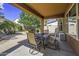 Covered patio featuring an outdoor dining set, seating, grill, and landscaped yard at 43330 W Delia Blvd, Maricopa, AZ 85138