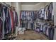 Large walk-in closet with wood floors and hanging rods providing ample storage space at 43330 W Delia Blvd, Maricopa, AZ 85138
