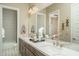 Bright bathroom with double sinks, marble countertop, decorative fixtures, and tiled shower at 43712 N Acadia Way, New River, AZ 85087