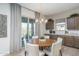 Bright dining room featuring hardwood floors, round table, stylish chandelier, and large glass patio door at 43712 N Acadia Way, New River, AZ 85087