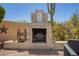 Stone fireplace with 'Life is better on the patio' sign, offering a relaxing outdoor gathering spot at 4727 E Rancho Caliente Dr, Cave Creek, AZ 85331