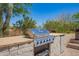 Outdoor kitchen area featuring a built-in stainless steel grill and a stone countertop at 4727 E Rancho Caliente Dr, Cave Creek, AZ 85331