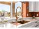 Close-up of kitchen sink with gold faucet, quartz countertops, and a large window at 4727 E Rancho Caliente Dr, Cave Creek, AZ 85331