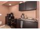 Kitchenette area with a stainless steel sink, modern cabinets, and small fridge and microwave at 4727 E Rancho Caliente Dr, Cave Creek, AZ 85331