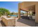 Spacious covered patio with an outdoor kitchen, grill, and ample seating overlooking a beautiful pool at 4727 E Rancho Caliente Dr, Cave Creek, AZ 85331