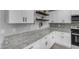 Bright kitchen with sleek white cabinets, granite countertops, modern backsplash, and stainless steel microwave and oven at 4732 S 38Th Gln, Phoenix, AZ 85041