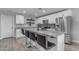 Modern kitchen features a center island with barstool seating, granite countertops, stainless steel appliances, and white cabinetry at 4732 S 38Th Gln, Phoenix, AZ 85041