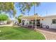 Expansive backyard showcasing a patio, lush lawn, mature trees, and outdoor seating area at 4950 N 78Th St, Scottsdale, AZ 85251