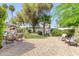 Serene backyard with gravel, mature trees, and comfortable seating area for relaxation at 4950 N 78Th St, Scottsdale, AZ 85251