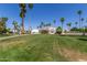 Beautifully landscaped community with lush lawn, mature palm trees, and attractive building exteriors under a clear blue sky at 4950 N 78Th St, Scottsdale, AZ 85251