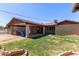 Backyard features lush grass, brick accents, covered patio, and garage access at 501 E Hill Dr, Avondale, AZ 85323