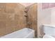 Cozy bathroom featuring a shower-tub combination with stylish tile surround and corner shelves at 501 E Hill Dr, Avondale, AZ 85323
