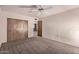 Spacious bedroom featuring carpeted floors, ceiling fan, and a sizable closet at 501 E Hill Dr, Avondale, AZ 85323
