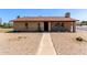Charming single-story home with a brick facade, gravel yard, and pathway to the front door at 501 E Hill Dr, Avondale, AZ 85323