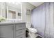 Updated bathroom with gray vanity, gray fixtures, modern shower curtain, gray floor tile, and decorative accents at 5401 N 104Th Dr, Glendale, AZ 85307