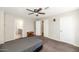 Simple bedroom with beige walls and carpet, a gray bed set, white doors, and a ceiling fan at 5401 N 104Th Dr, Glendale, AZ 85307