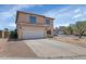 View of the home's front exterior highlighting the two-car garage and desert landscaping at 5401 N 104Th Dr, Glendale, AZ 85307