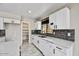 Bright kitchen features white cabinets, modern countertops, gray backsplash, and stainless steel appliances at 5401 N 104Th Dr, Glendale, AZ 85307
