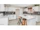 Updated kitchen with white cabinets, tile backsplash, and eat-in island with barstool seating at 5401 N 104Th Dr, Glendale, AZ 85307