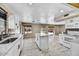 Open kitchen features white cabinets, an island, updated appliances, and sliding door at 5401 N 104Th Dr, Glendale, AZ 85307
