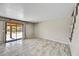 Open-concept living room with tile floors, leading to a glass sliding door and view of the backyard at 5401 N 104Th Dr, Glendale, AZ 85307