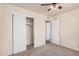 Bedroom with carpet, ceiling fan, closet with sliding doors, and an entrance to another bedroom at 5415 E Butte St, Mesa, AZ 85205