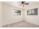 This bedroom features updated carpet, two windows providing lots of natural light, and neutral paint at 5415 E Butte St, Mesa, AZ 85205