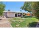 Well-maintained backyard with a covered patio, perfect for outdoor dining and relaxation, with grass and large tree at 5614 N 20Th Dr, Phoenix, AZ 85015