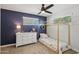 Cozy bedroom with a unique house frame bed, dark blue accent wall, and dresser at 5614 N 20Th Dr, Phoenix, AZ 85015