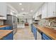 Bright kitchen featuring stainless steel appliances, butcher block countertops, and view to living area at 5614 N 20Th Dr, Phoenix, AZ 85015