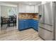 Modern kitchen boasting stainless steel refrigerator and blue cabinets with tiled floors at 5614 N 20Th Dr, Phoenix, AZ 85015