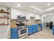 Well-lit kitchen featuring stainless steel appliances, blue cabinets, and stylish backsplash at 5614 N 20Th Dr, Phoenix, AZ 85015