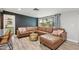 Bright living room featuring a comfortable leather sectional, chic gold coffee table, and large windows overlooking the backyard at 5614 N 20Th Dr, Phoenix, AZ 85015