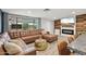 Cozy living room featuring a large leather sectional, stylish fireplace, and seamless access to the outdoor space at 5614 N 20Th Dr, Phoenix, AZ 85015