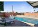 Backyard pool with lounge chairs, umbrellas, and a secure brick privacy fence at 6802 E Oak St, Scottsdale, AZ 85257