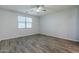 A well lit bedroom featuring wood-look flooring, a ceiling fan, neutral walls and window with blinds at 7261 E Teal Way, San Tan Valley, AZ 85143