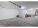 Spacious garage featuring epoxy floors, overhead lighting, and built-in shelving at 7261 E Teal Way, San Tan Valley, AZ 85143